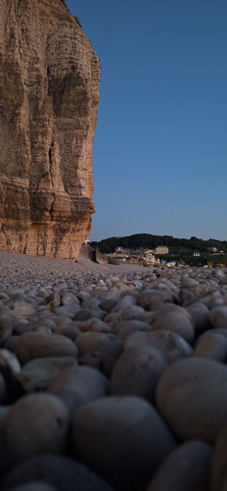 Der Steinstand und die Klippen von Étretat mit der dahinterliegenden Stadt.