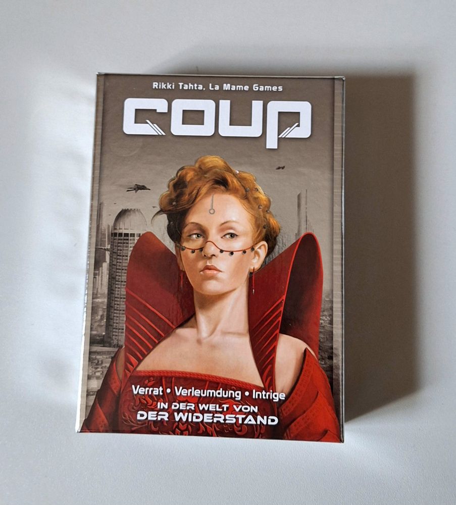 Die Schachtel des Spiels "Coup" von Rikki Tahta und La Mama Games, mit dem Untertitel "Verrat - Verleumdung - Intrige in der Welt von Der Widerstand"