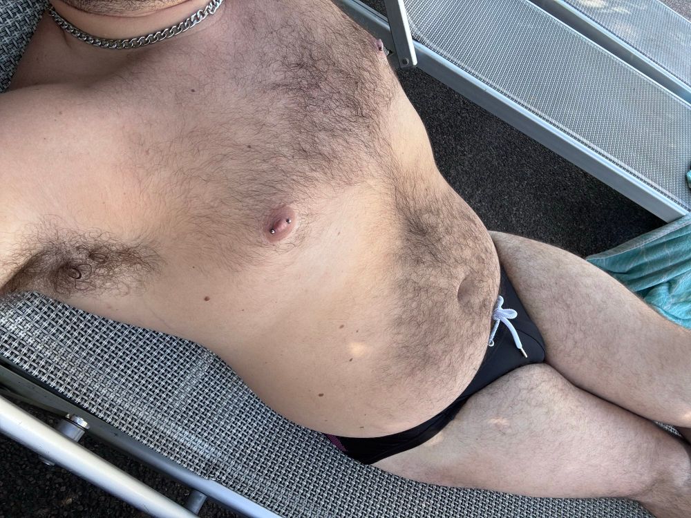 Hairy gay cub in a black Speedo and pierced nipples