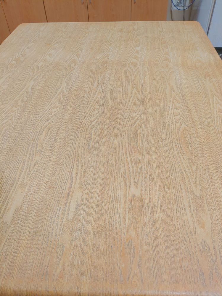 A photo of a wooden table with a repeating pattern, due to being assembled from planks made of the same piece of wood