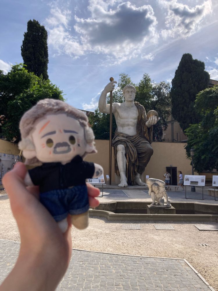 Rights Izzy doll held up in front of the reconstruction of the statue of constantine in the gardens of the capitoline museums. it is a very large statue and izzy is very impressed. 