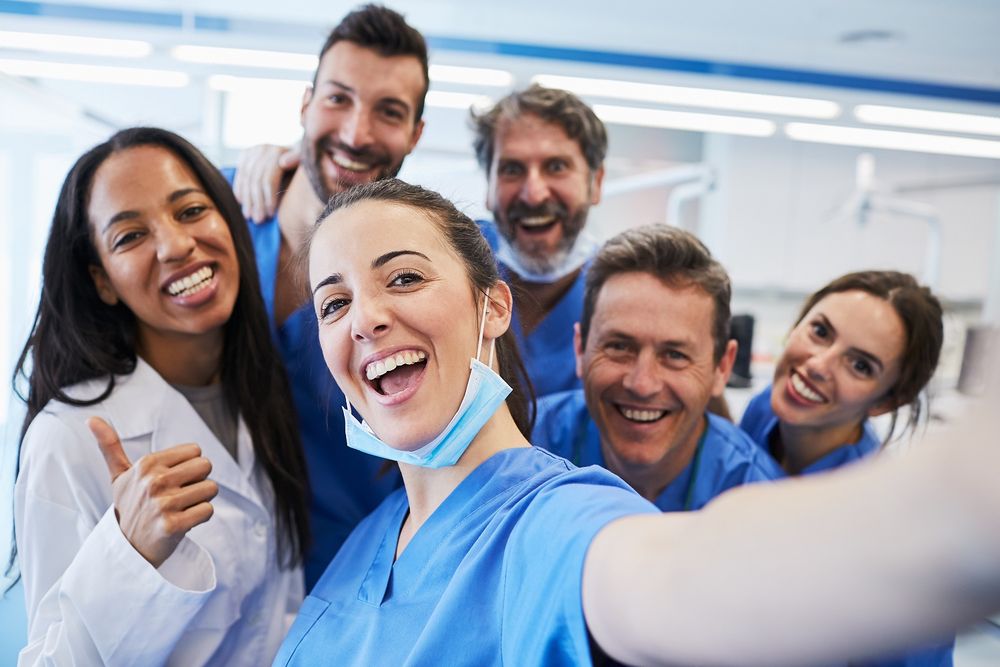 A group of cheerful healthcare professionals in blue scrubs