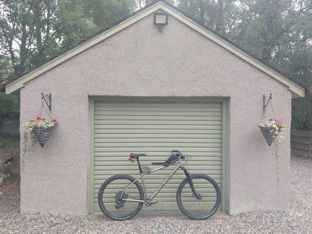 A mountain bike, leaning up against a garage door.