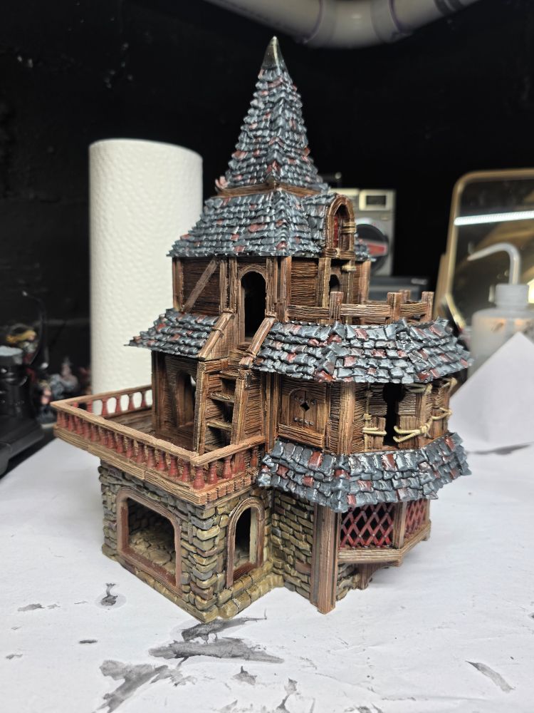 Painted 32mm scale medieval building, kind of ramshackle with a steepled roof