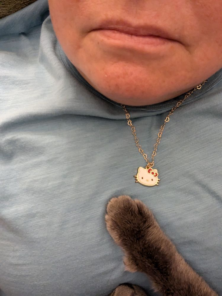 Half face with kitten paw over heart