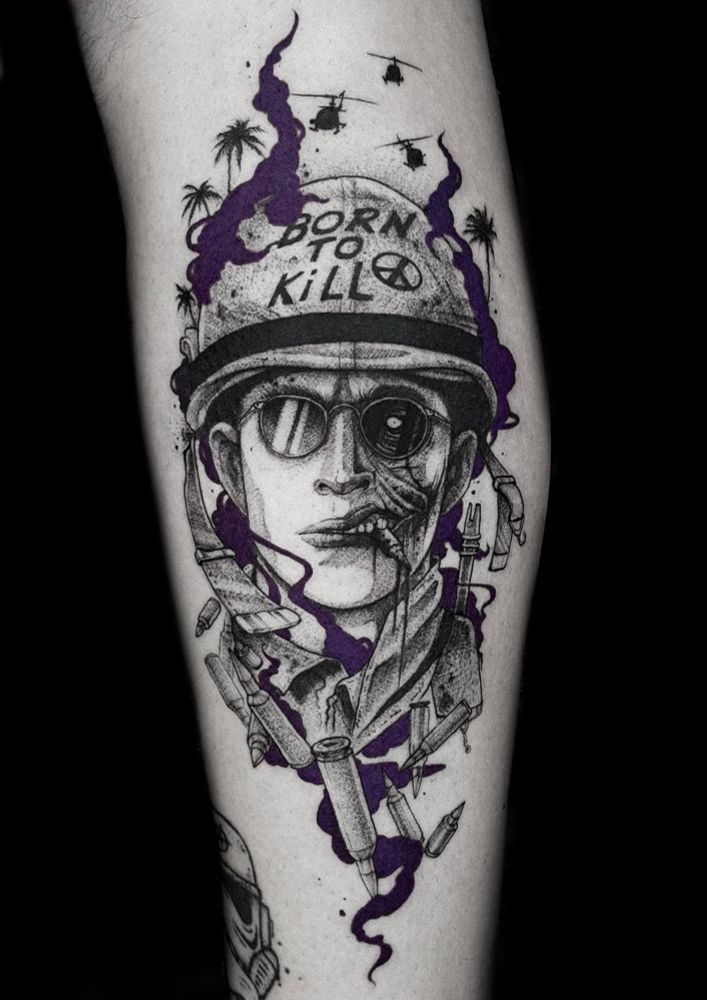 Pvt Joker portrait tattoo, character from Kubirik’s movie Full metal jacket. Soldier wearing a helmet with a ‘born to kill’ tag, chewing on a bullet, wearing glasses, half face normal half face horror. Helicopters and palm trees in the background. Bullets floating around the portrait and purple smoke that draws out some devil horns silhouette. 