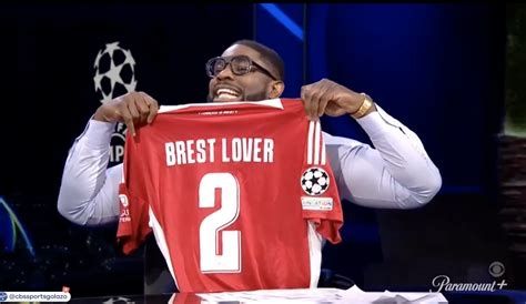 Micah Richards holding up his personalized Brest shirt.