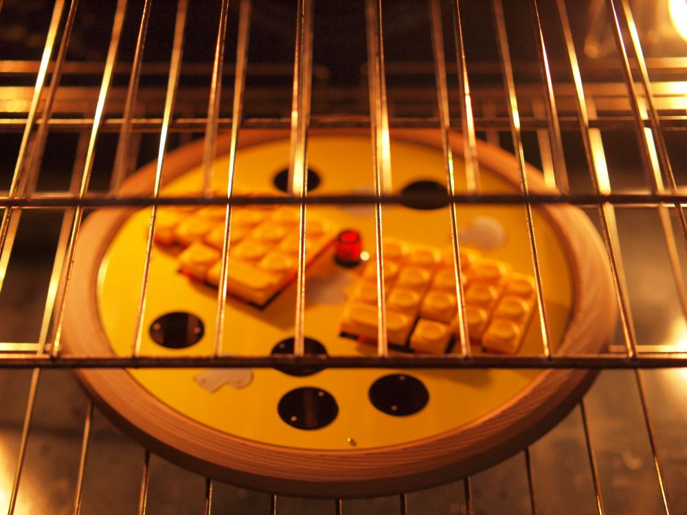 40% Keyboard in the shape of a pizza, it is on the racks of a oven 