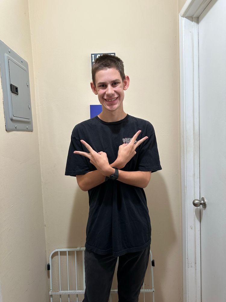 My son standing against the wall smiling