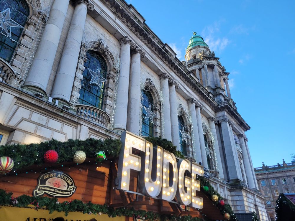 Photo of City Hall with a large sign for fudge in the foreground 
