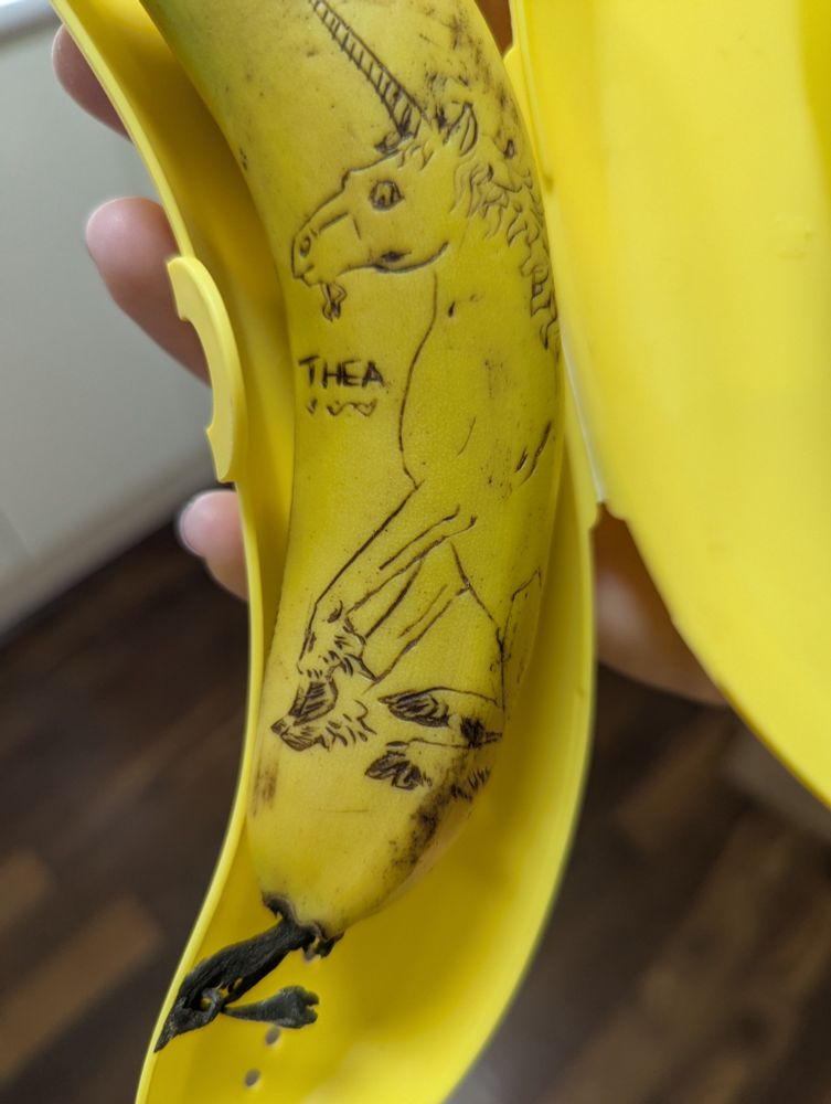 A banana carved with a seated, cloven-hoofed unicorn design