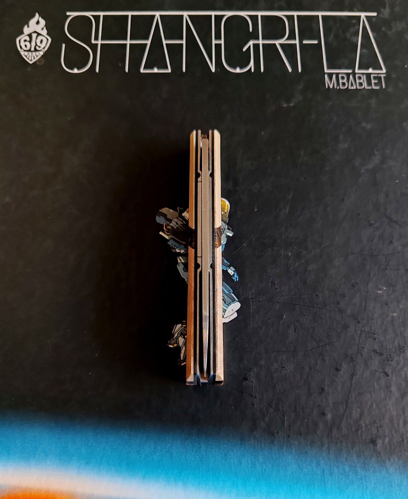 Cputeau mis sur tranche pointe vers le bas 
En fond l'album shangri-la de m bablet
