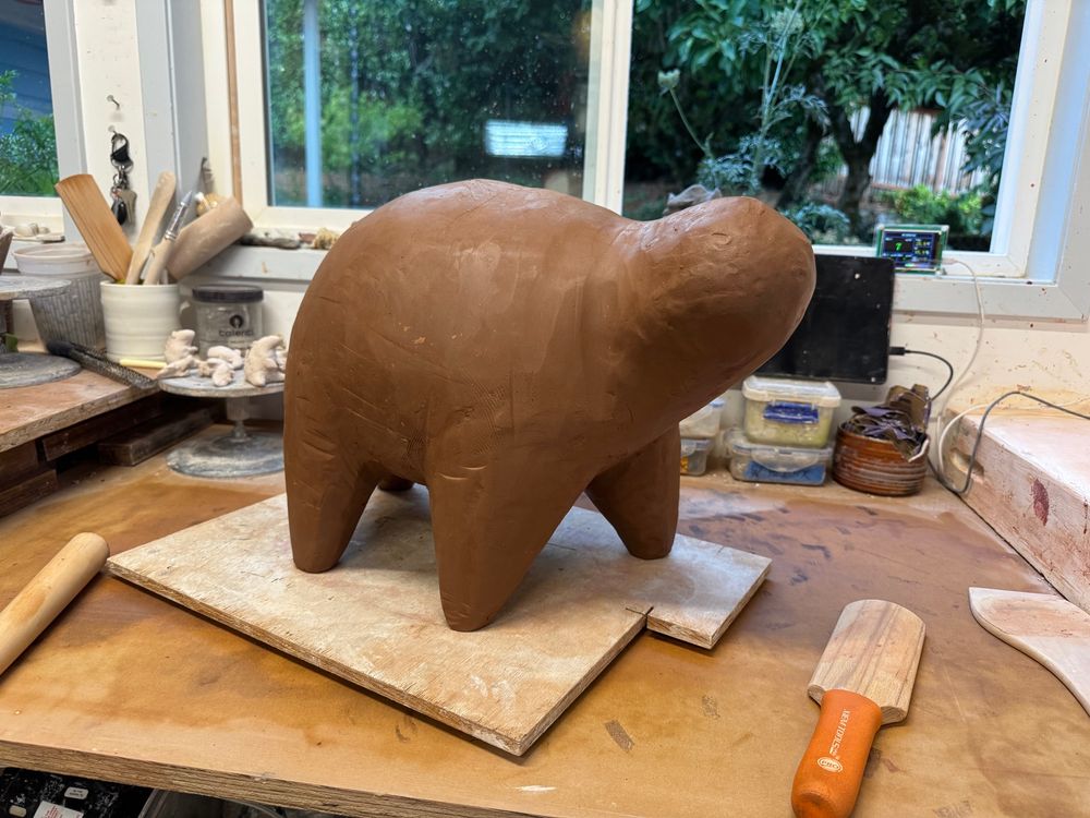 A large (2ft long) sculpture of a round body beast, on my work table. The head and legs are already attached. 