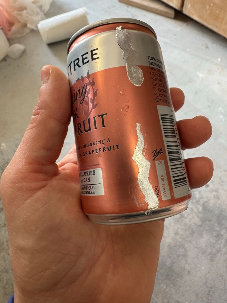 A small can with a stripe of fake silver leaf on it. It’s a bit too flat against the can for my taste. 