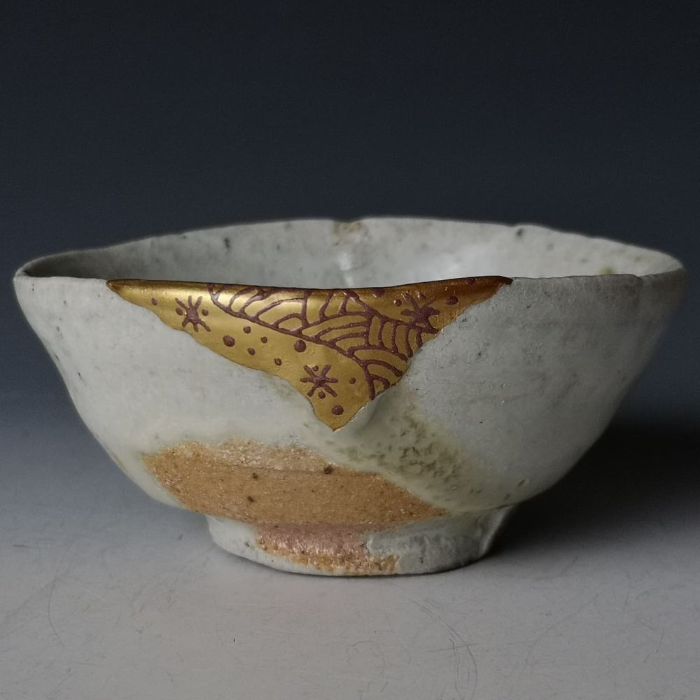 A pot with a whole shard missing, rebuild out of wood, lacquer, and gold 