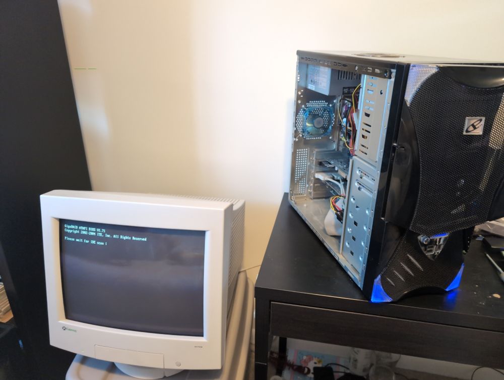 An old cyber power PC case w/ the side panel off. Beside it on a tote is a gateway EV700 CRT monitor