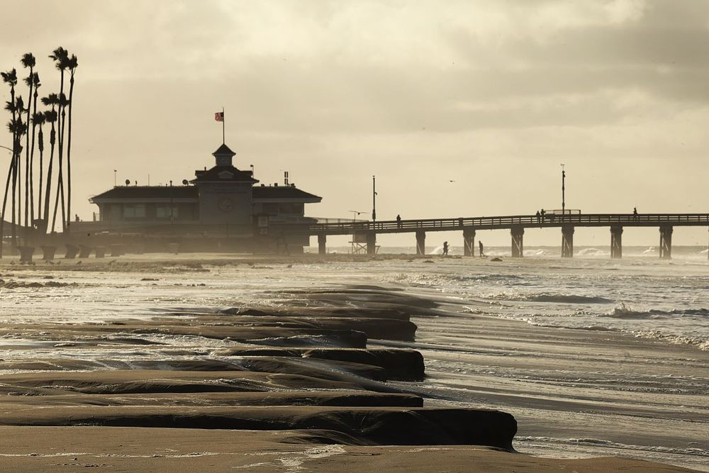 A photo looking toward Newport Beach Pier showing the surf covering most of the beach.