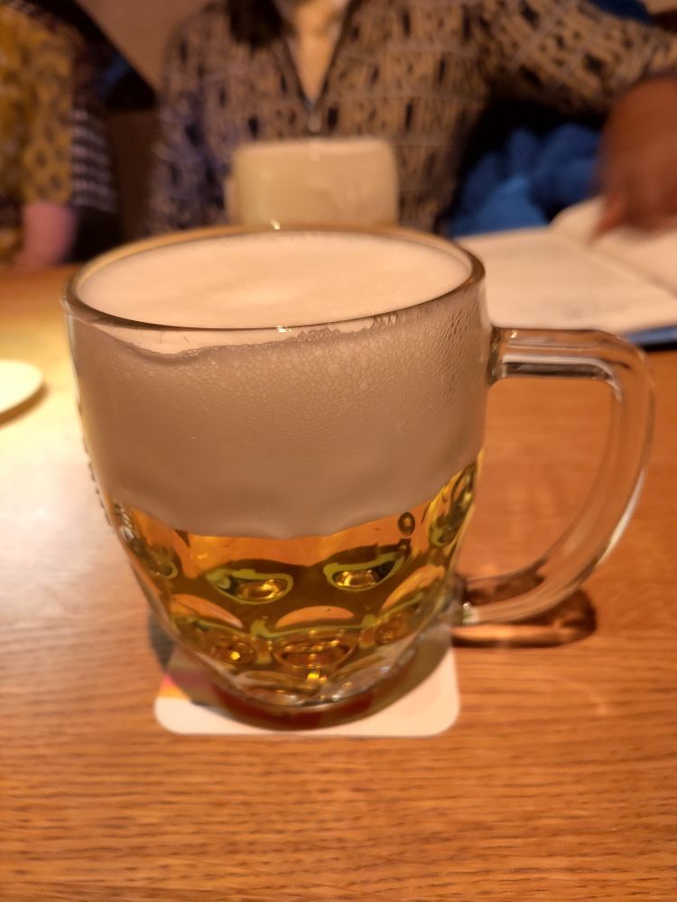 Large glass of light beer with lots of foam