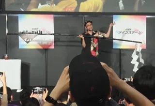 ZUN [[Jun'ya Ōta]] [[John Touhou]] HOLIDING UP THE GOHAI FROM TOUHOU 20S REIMU IN AN EVENT. 