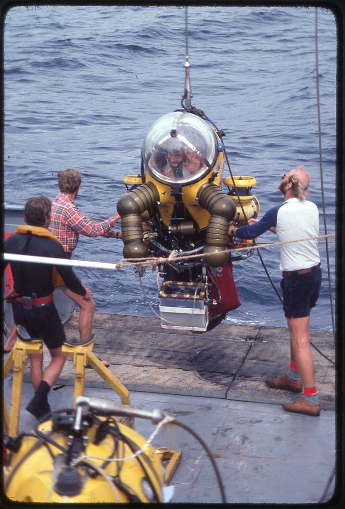 Bruce Robison waves from inside a WASP atmospheric diving suit (ADS) being launched off the fantail of the R/V New Horizon in 1982. This is in the Santa Barbara Basin.