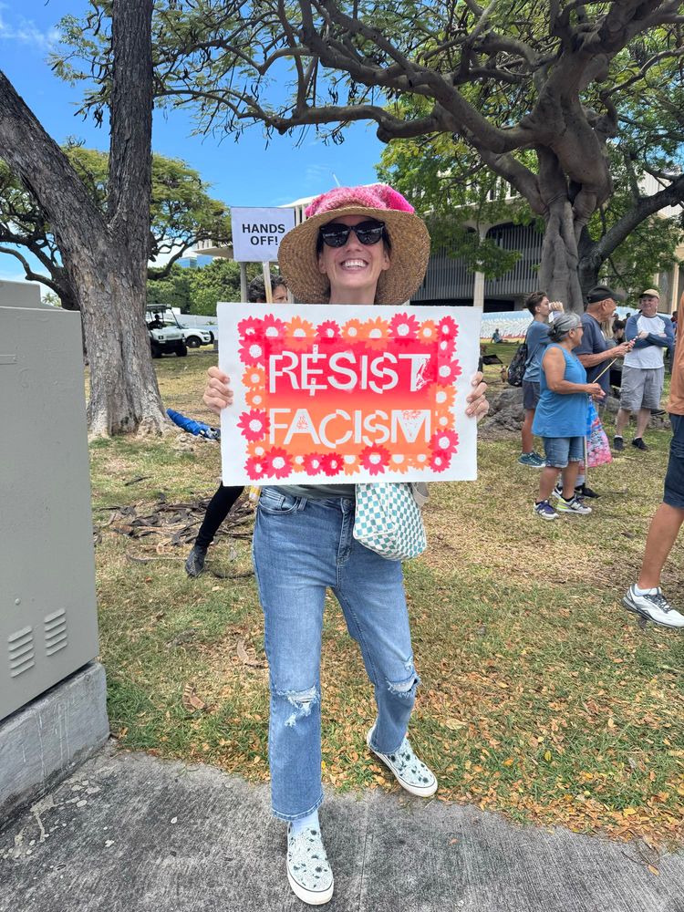 Protestor with colorful sign “resist racism”