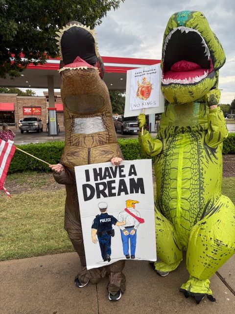 2 inflatable tyrannosaurs at the protest. Artwork for poster on the right by Jesse Duquette.