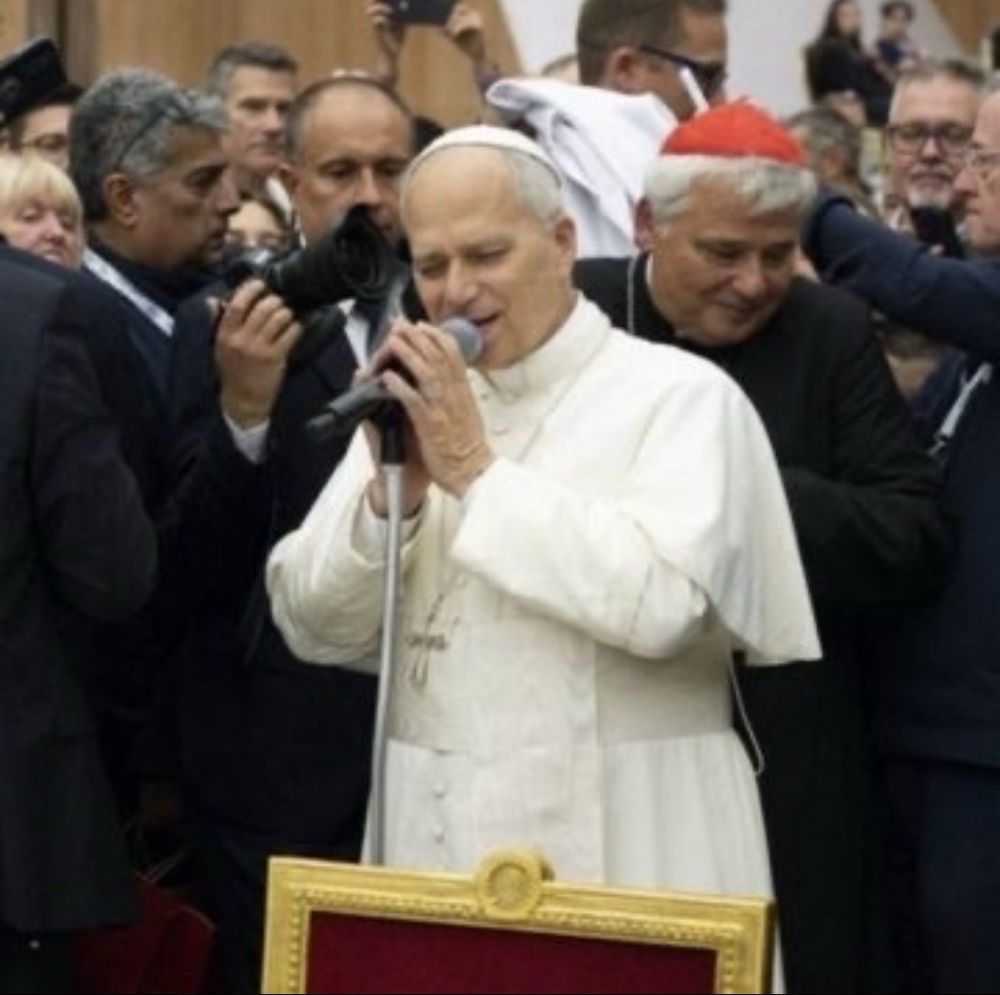 Pope Leo singing into a microphone. 