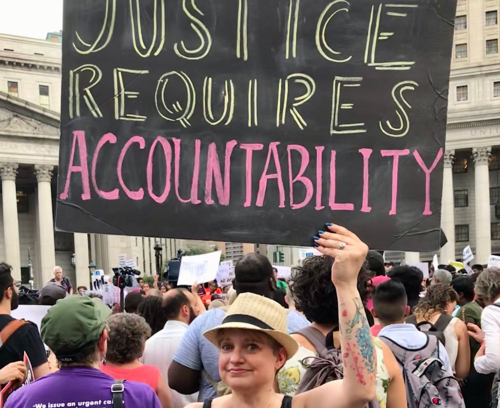 Protest sign reading Justice Requires Accountability 
