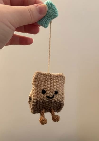 A knitted tea-bag friend dangling from it's string