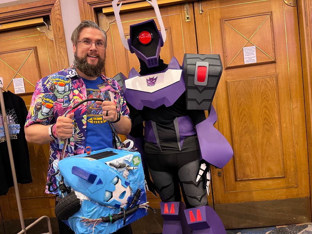 Your resident idiot JSpaced, beard and new Hawaiian shirt, proudly holds the compacted remains of animated Blurr, ready to do his duty for Shockwave… sorry, Longarm Prime. The purple animated Shockwave cosplay is awesome!