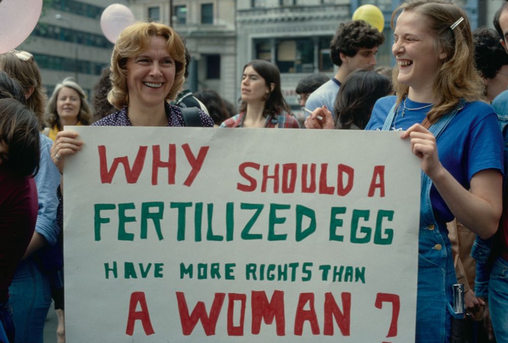 Protesters at a 1981 pro choice demonstration in NYC holding a sign that reads “why should a fertilized egg have more rights than a woman?”