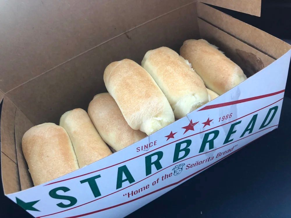 A white cardboard box of sweet yeasted rolls from Starbread Bakery.