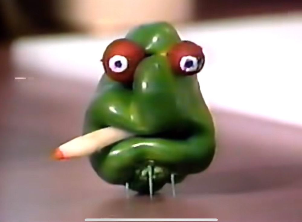 A green pepper with buggy radish eyes smoking a doobie.