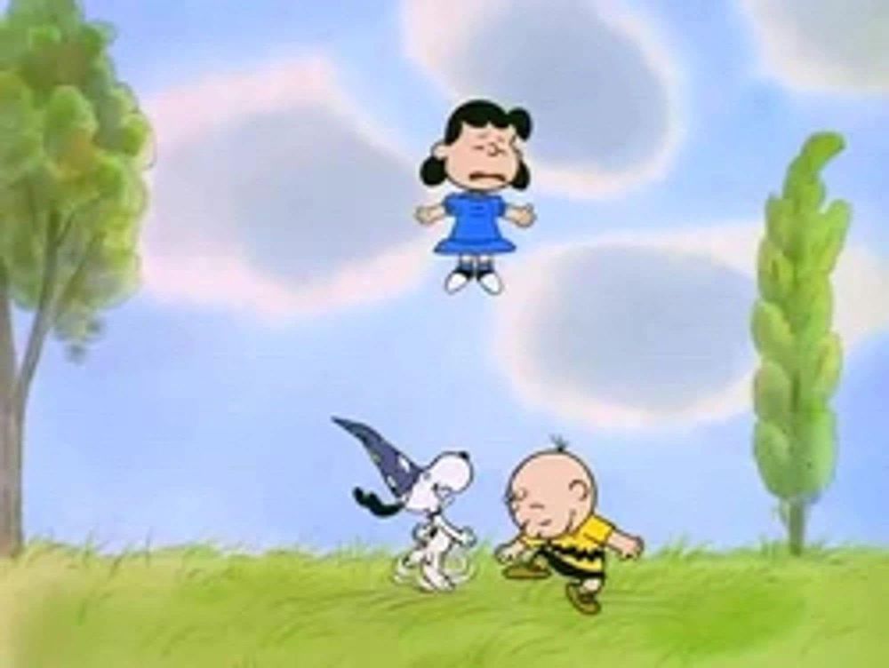 I forget what Peanuts special this is from. Charlie Brown and Snoopy, wearing a wizard cap, dance a jig in the middle of a field. Lucy is floating in the air in a Christ pose, a look of misery on her face.