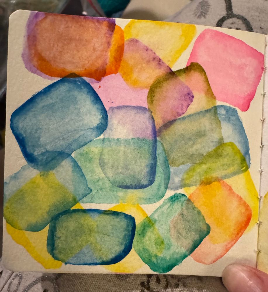 Several translucent organic watercolor boxes layered on top of each other in bright colors. 