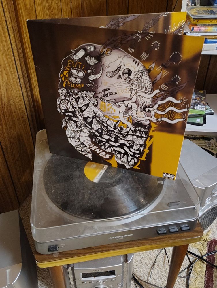 A copy of Portugal. The Man's "Evil Friends" sitting on top of a turntable. 