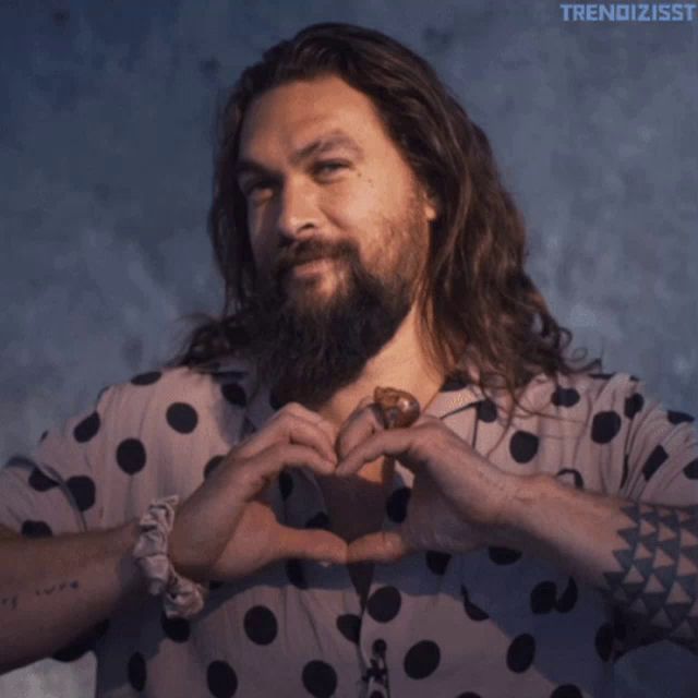 a man with long hair and a beard wearing a polka dot shirt with the word trendizsst on the bottom