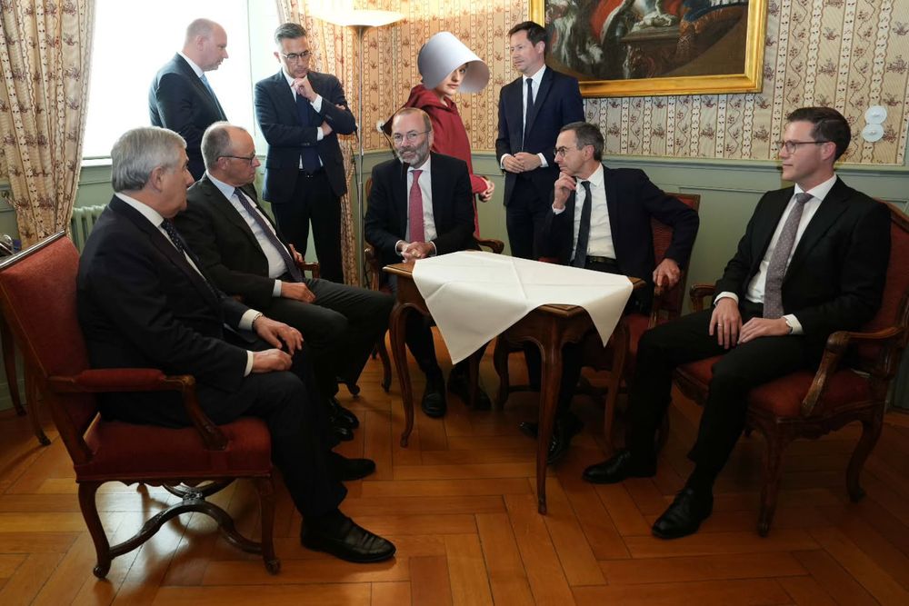 Alte Männer feiern das angebliche Aus vom Verbrenneraus der EU und June/Desfred aus Handmaids Tale wurde fotomontiert in den Hintergrund