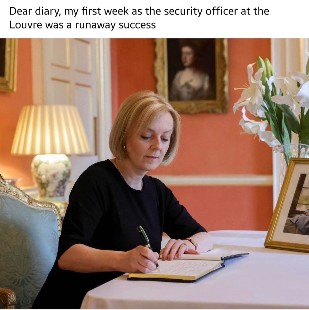 Liz Truss, dressed in black, sits at a desk writing her memoirs: "Dear diary, my first week as the security officer at the Louvre was a runaway success".
