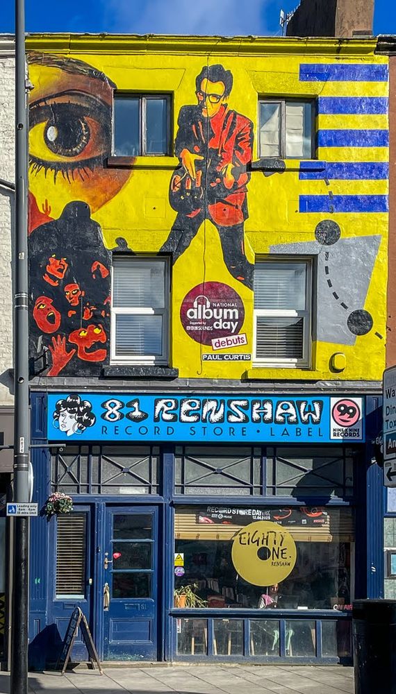 Record shop with a painted wall showing Elvis Costello