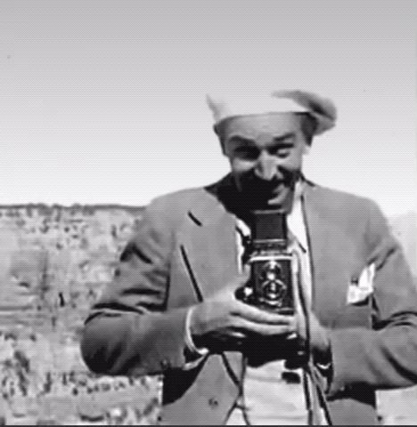 Walt Disney turns around in front of the viewer to take a picture 