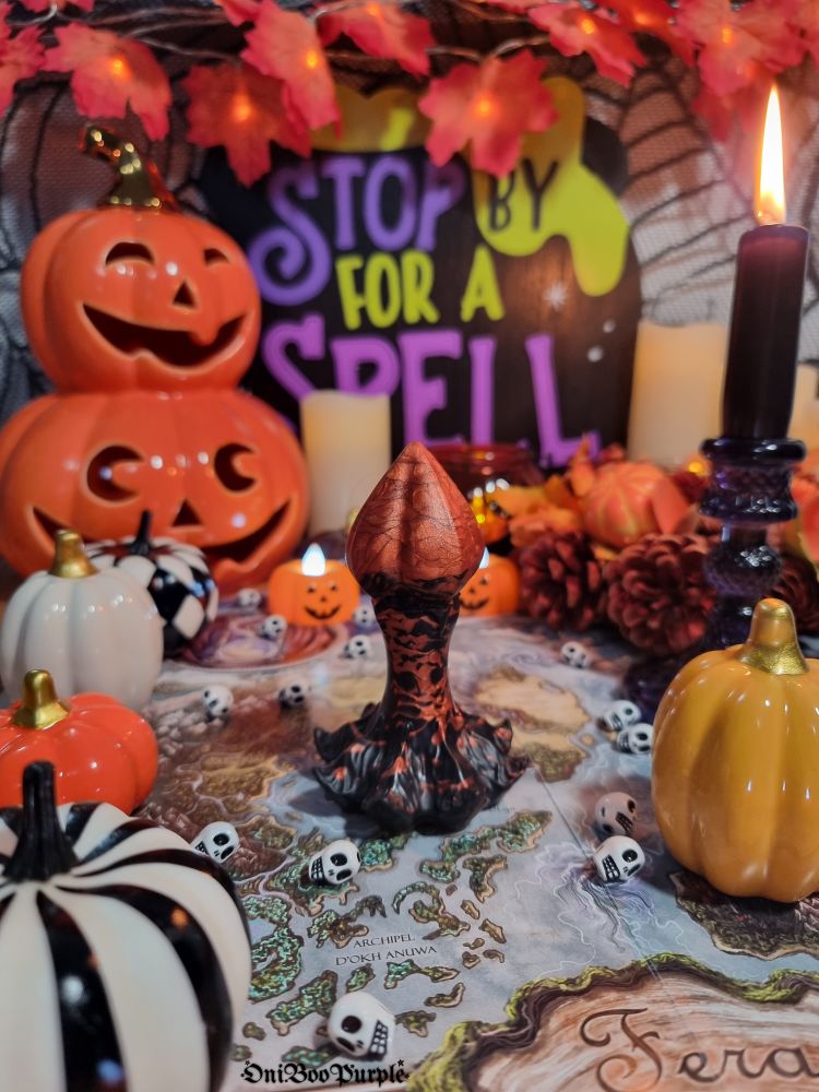 The Nymf plug dildo from fera daemon in the middle of a pumpkin and skull decoration for a pretty Halloween atmosphere. 