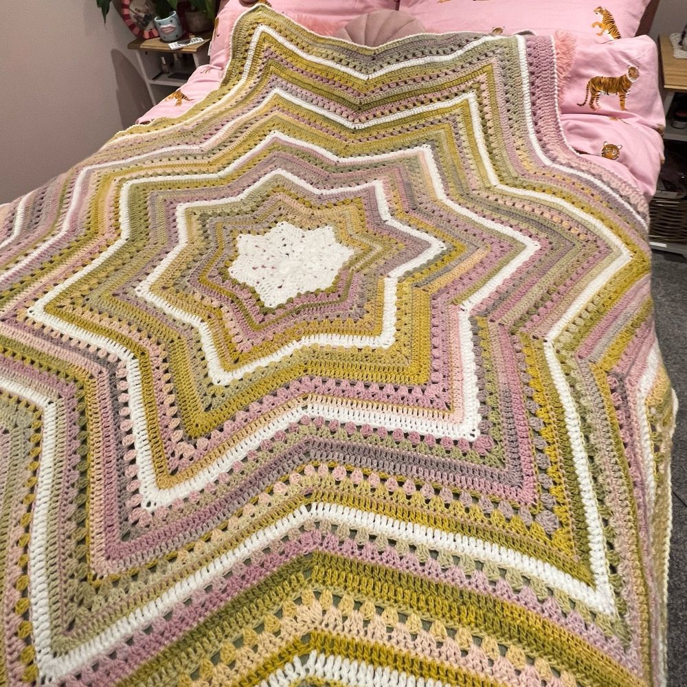 Crochet six-day star blanket in pinks, greens and white 