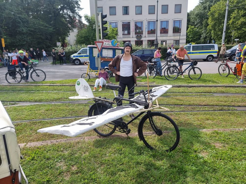 Flugzeugflügel an Fahrrad angebaut. Felix mit Fliegermütze und -Brille.