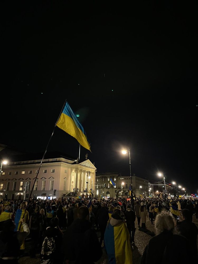 Ukrainische Flagge vor einem Gebäude der HU Berlin, Unter den Linden mit den Demonstranten. 