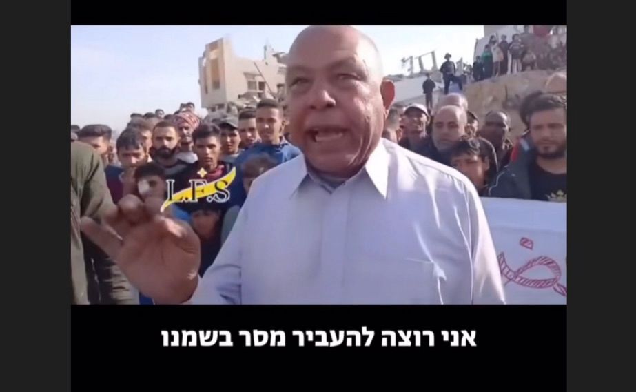 Foto von der Seite der israelischen NGO Standing Together. Es zeigt einen Mann der in Gaza gegen den Krieg protestiert. Hinter ihm weitere Demonstranten mit Transparenten.