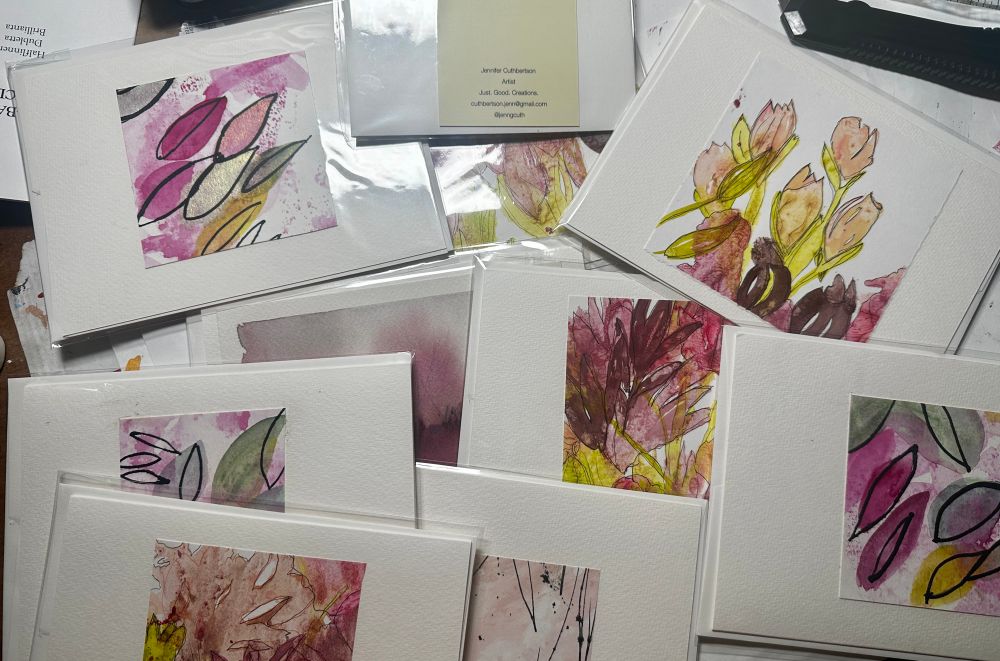 A pile of handmade greeting cards from watercolor and acrylic paintings and papers.