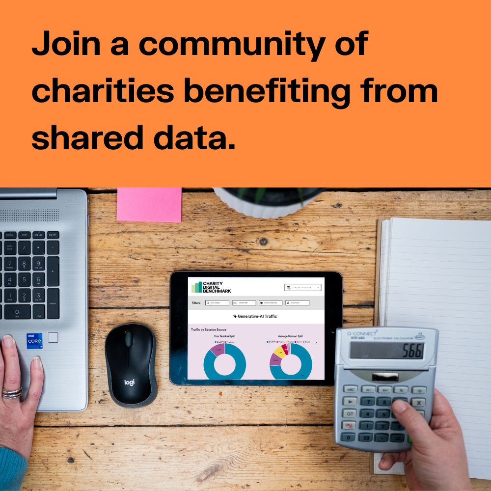 Black text on orange reads Join a community of charities benefiting from shared data. A picture of a hand on laptop sat on wooden table, with tablet with Charity Digital Benchmark site on the screen. A notepad and calculator by the other hand. 