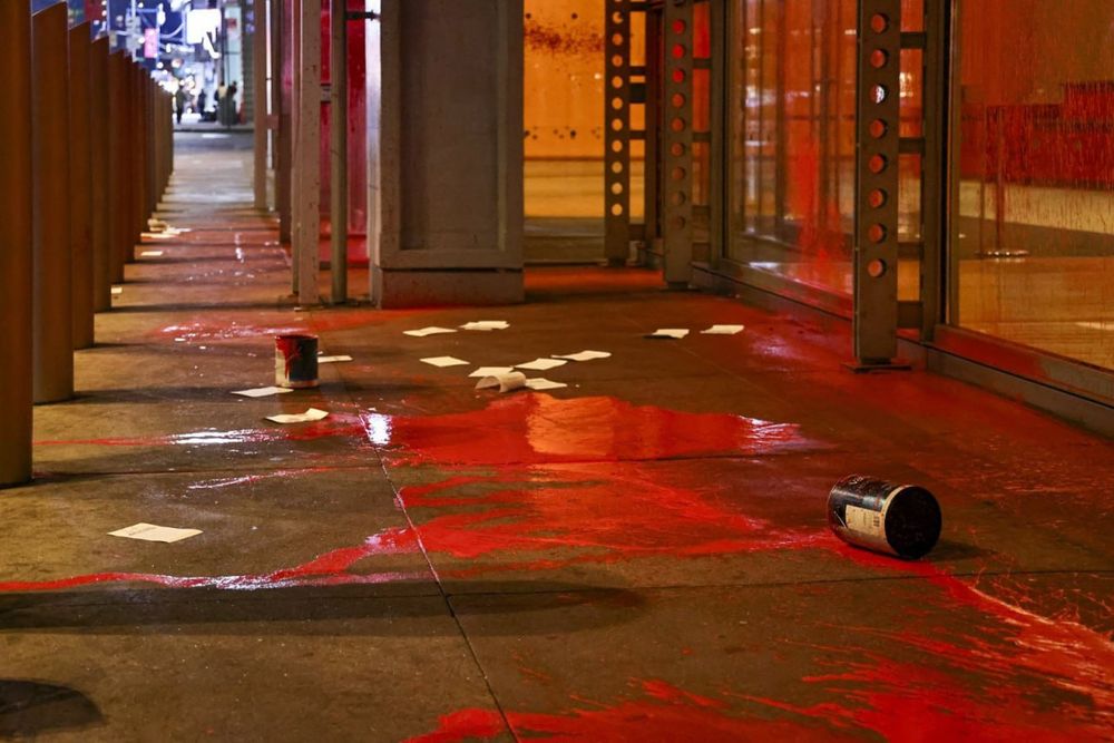 Red paint splattered across the portico of the gray lady building