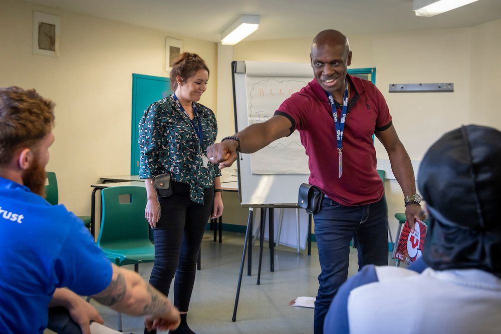Spark Inside coaches Lilian Flynn and Michael Roper working with a group of young men inside HMP/YOI Isis, London, United Kingdom